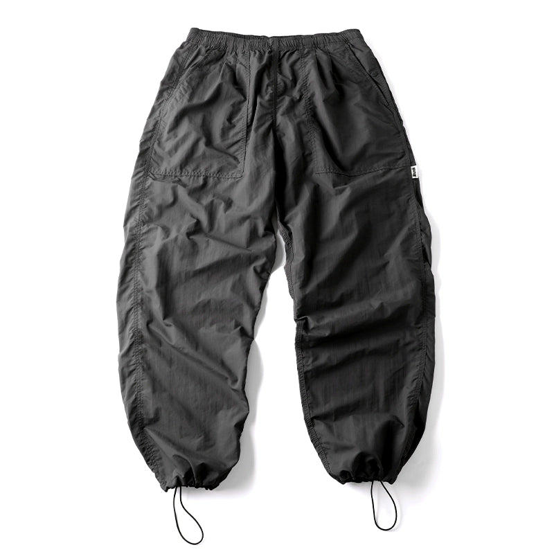 Black Sakura Breeze waterproof breathable casual pants with a relaxed fit, laid flat showing the front view. The pants feature an elastic waistband, side pockets, and adjustable drawstrings at the ankles.