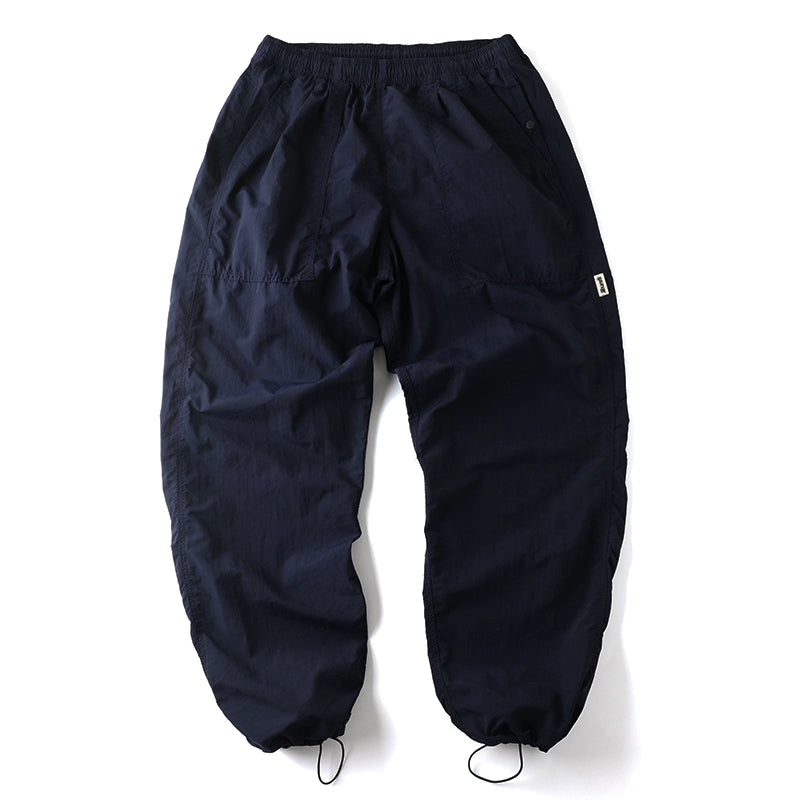 Full back view of the navy Sakura Breeze waterproof breathable casual pants, laid flat, showing the relaxed fit, elastic waistband, and adjustable elastic cuffs.