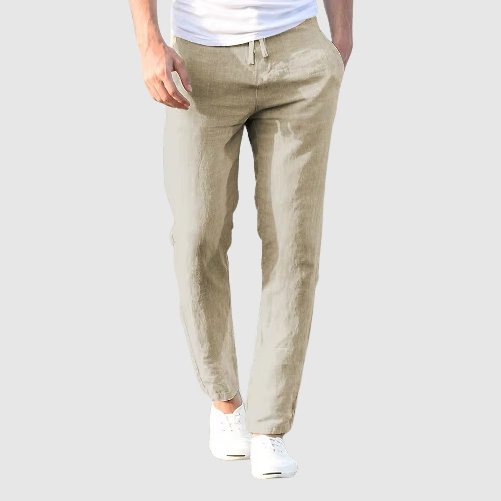 Seaside Retreat men's beige linen pants with relaxed fit, shown on a model wearing a white t-shirt and white sneakers. Perfect for coastal style and comfortable outfits.