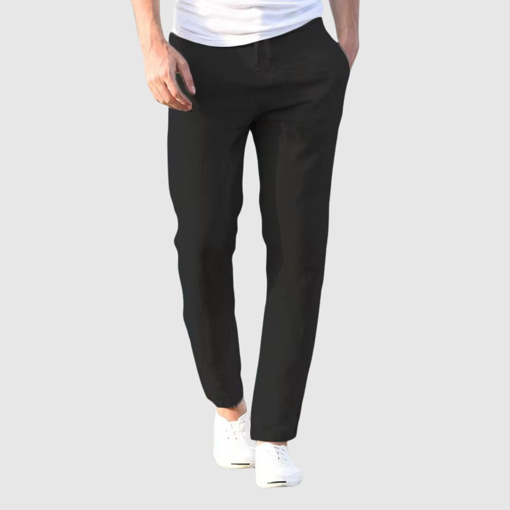 Seaside Retreat men's black linen pants with relaxed fit, styled with a white t-shirt and white sneakers. Versatile bottoms for casual and comfortable wear.