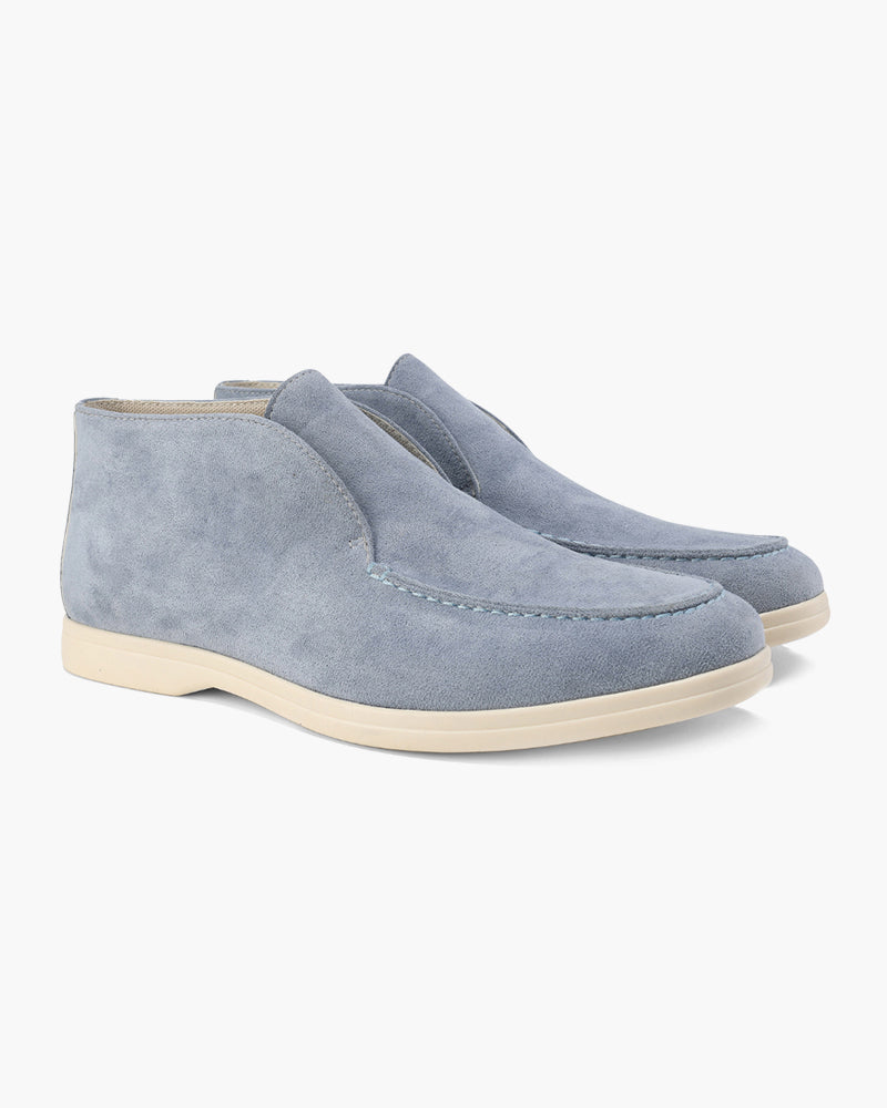Pair of fog blue suede loafers with classic detailing, mid-cut style, on a white background.