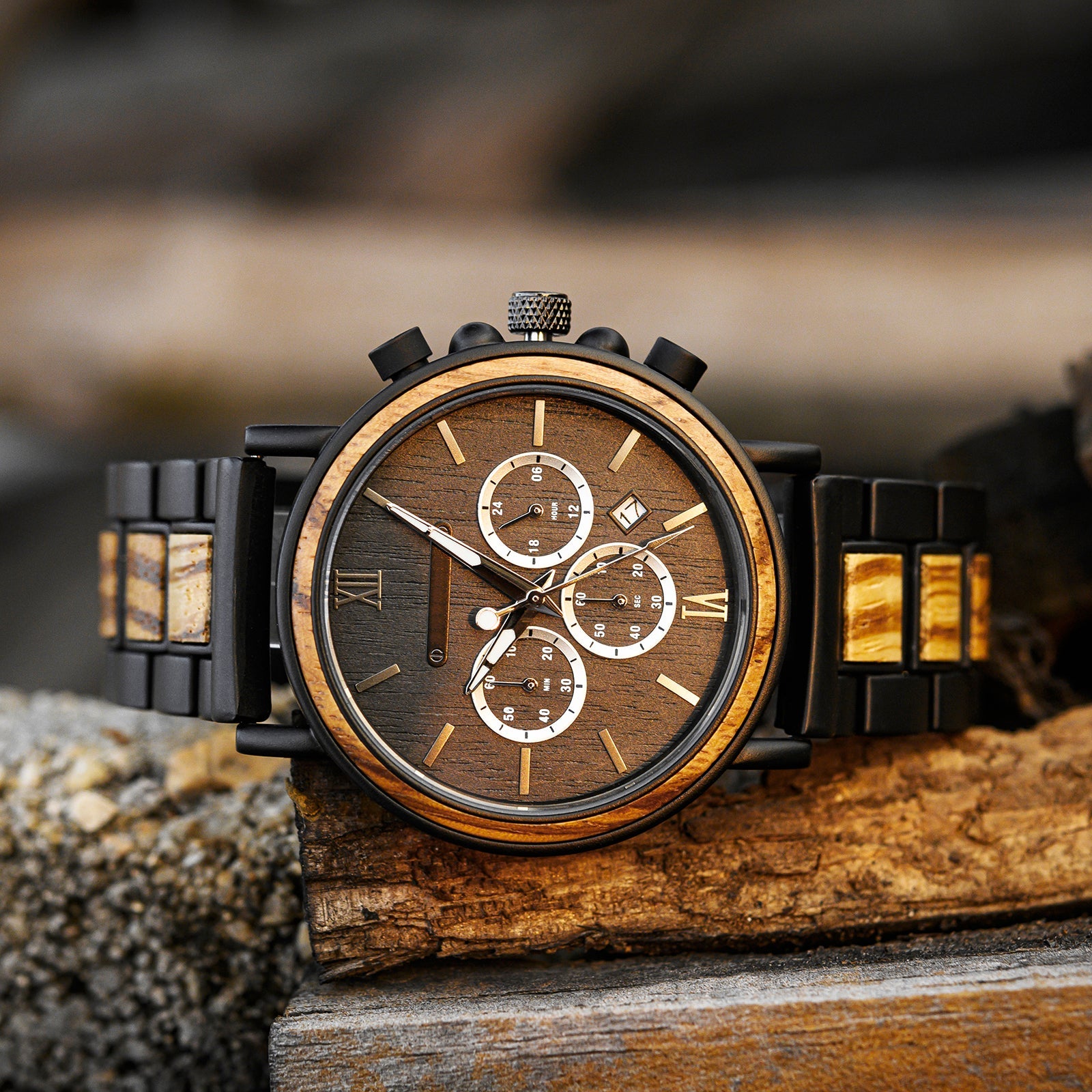 Close-up of the Timberline men's watch featuring a brown dial, chronograph subdials, and a black band with whiskey oak wood accents, resting on a rustic wooden surface.