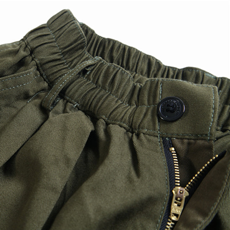 Close-up view of the green Urban Luxe wide-leg casual pants waistband, highlighting the elastic detail, black button, and brass zipper.