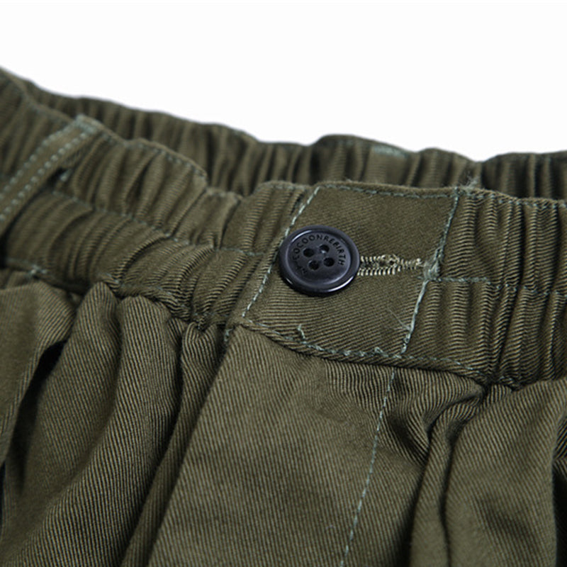 Close-up view of the green Urban Luxe wide-leg casual pants waistband, highlighting the elastic detail and a black button closure.