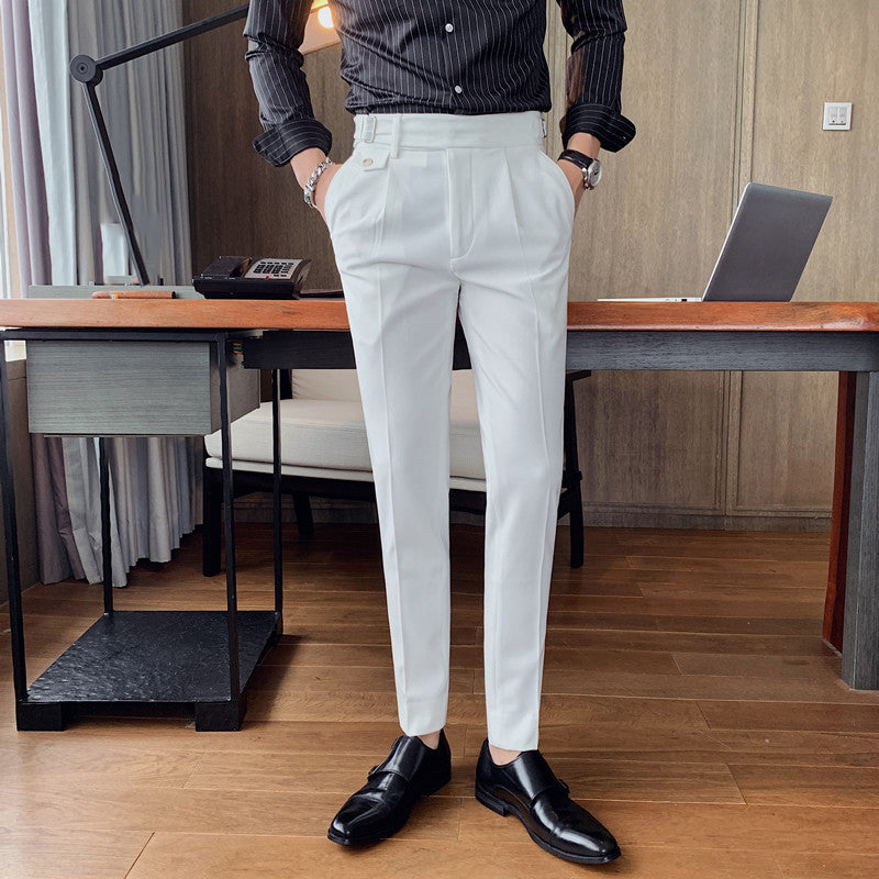 A man models Vintage Charm men's retro white suit pants with a tailored fit and lightweight fabric, paired with a striped black shirt and black loafers in an office setting.
