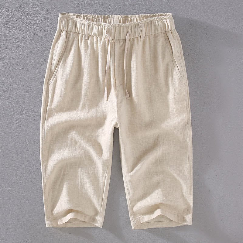 Men's natural Linen colored cropped pants with drawstring waist and side pockets, laid flat. Perfect for comfortable casual wear.